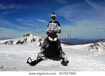 Man With Helmet In Snowmobile In  Snowy Summit