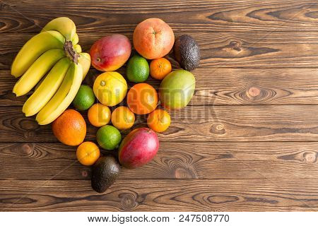 Heart-shaped Still Life Of Mixed Healthy Fresh Tropical Fruit With Bananas, Mango, Orange, Lemon, Li