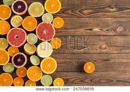 Assorted Fresh Cut Citrus Fruits On A Wooden Background With Copy Space And A Single Clementine Set 