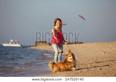 Girl Playing With A Dog On The Beach