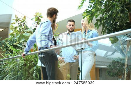 Young Modern People In Smart Casual Wear Having A Brainstorm Meeting While Standing Behind The Glass