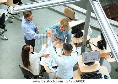 Top View Of Young Modern Colleagues In Smart Casual Wear Working Together While Spending Time In The