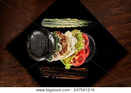 Black Burger On Square Plate With Spicy Sauces On Vintage Wooden Background, Top View, Close-up, Sel