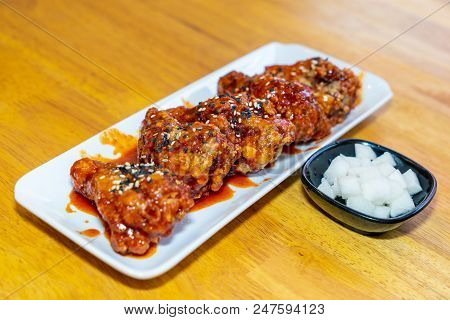 Spicy Korean Chicken Wings In White Plate On Wooden Table