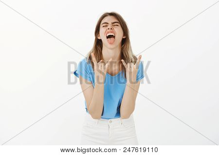 Portrait Of Excited Carefree Good-looking Woman With Fair Hair, Bending Towards Camera, Sticking Out