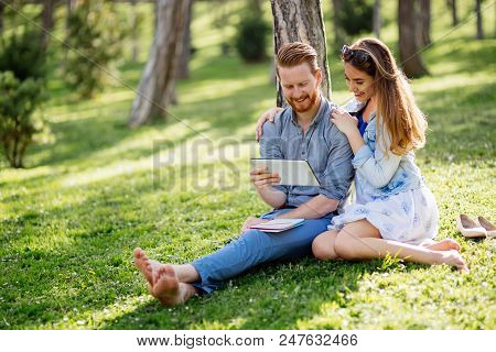 Beautiful Couple Studying Together For Exams In Nature