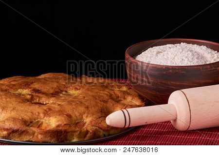 A Bowl With Flour And Apricot Cake On A Wooden Background On Black