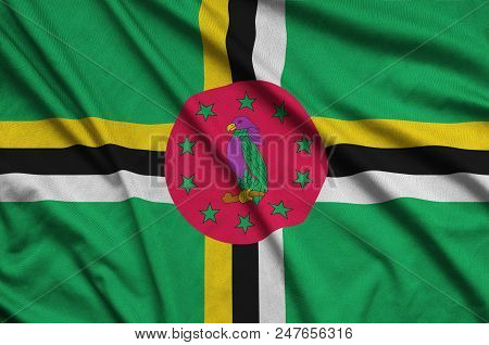 Dominica Flag  Is Depicted On A Sports Cloth Fabric With Many Folds. Sport Team Waving Banner