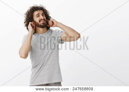 Bothered Handsome Hispanic Guy With Afro Hairstyle, Looking At Upper Right Corner With Annoyed Disgu