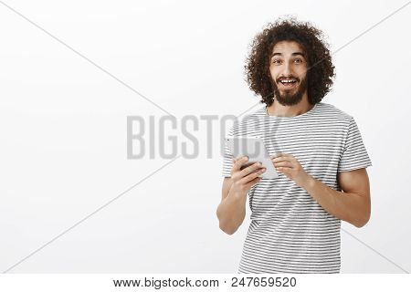 Portrait Of Happy Friendly Hispanic Bearded Man With Afro Hairstyle, Holding White Digital Tablet An
