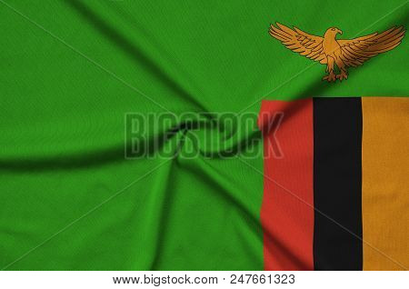 Zambia Flag  Is Depicted On A Sports Cloth Fabric With Many Folds. Sport Team Waving Banner