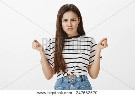 Offended Girl Looking Cute When Angry. Portrait Of Outraged Tender Feminine Woman, Raising Clenched 
