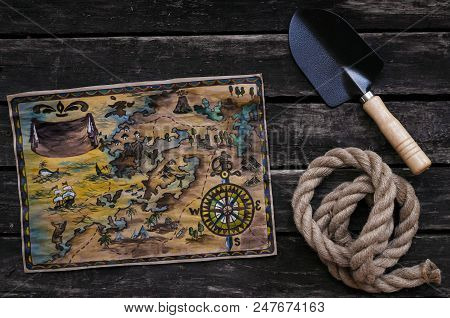 Treasure Map, Shovel And Rope On Old Wooden Table Background. Treasure Hunter Concept.