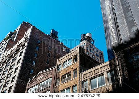 New York City, Usa - June 20, 2018: Low Angle View Of Old Buildings And Water Towers Against Sky In 