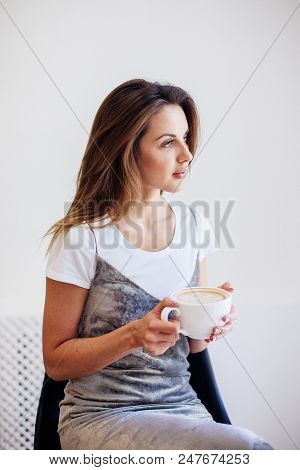 Close Up Of Beautiful Female Hand Holding Big White Cup Of Cappuccino Coffee.