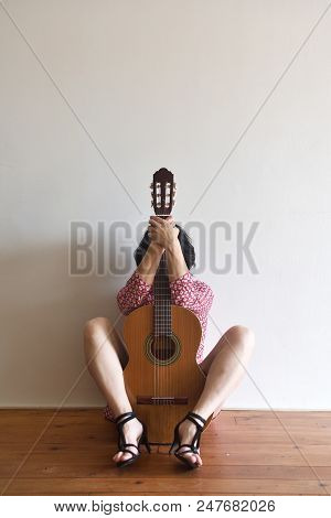 Portrait Of A Woman Sitting With A Guitar