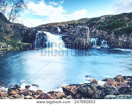 Pools And Majestatic Waterfalls Belllow Snowy Mountains. Blue Water Mirrorong Blue Cloudy Sky