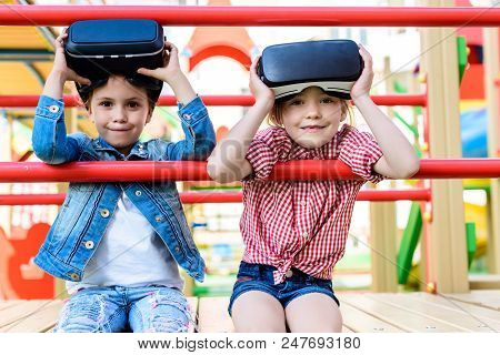 Adorable Little Children Taking Off Virtual Reality Headsets At Playground