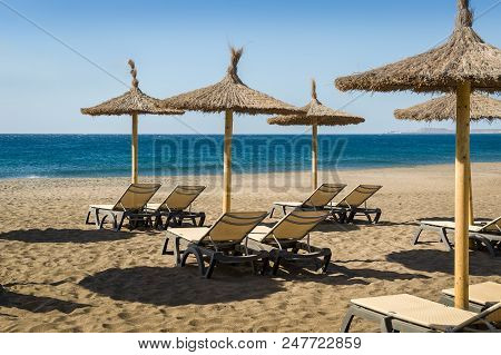 Beach Chairs And Umbrellas Of Playa De Tejita Sand. Tenerife, Spain.