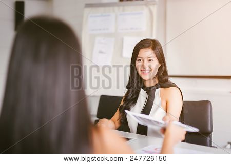 Business Woman Passing Document To Manager At The Office .the Office Worker Submits A Report On The 