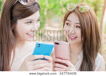 Two Beauty Women Smile With Braces And Use Phone Happily