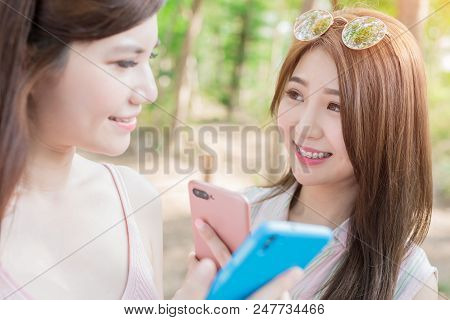 Two Beauty Women Smile With Braces And Use Phone Happily