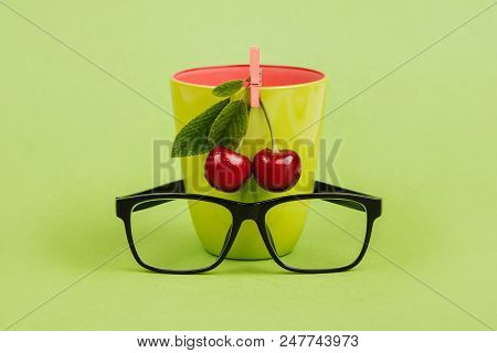Fresh Cherries With Green Glass And Glasses On Green Background