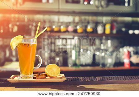 Hot Alcoholic Cocktail Grog With Slice Of Lemon And Straws At Glass At The Bar Counter With Copyspac