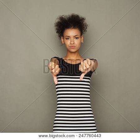 Woman Gesturing Thumbs Down Sign. Young African-american Girl Showing Negative Emotion, Symbolising 
