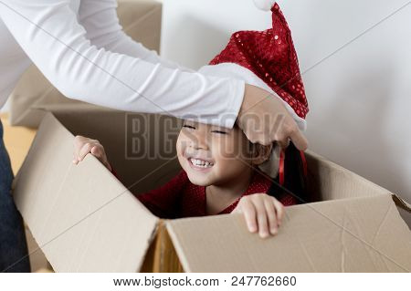 Asian Girl Playing In The Box At Home. Kid Sitting Inside Box With Attractive Smiling. Woman Trying 