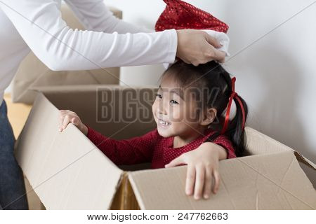 Asian Girl Playing In The Box At Home. Kid Sitting Inside Box With Attractive Smiling. Woman Trying 