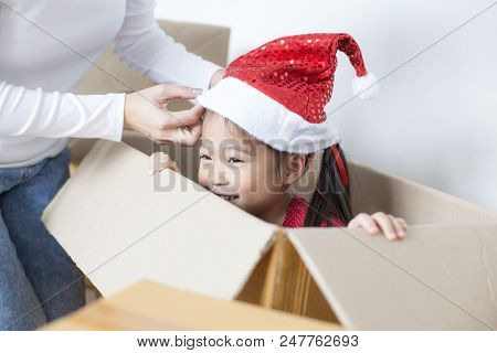 Asian Girl Playing In The Box At Home. Kid Sitting Inside Box With Attractive Smiling. Woman Trying 