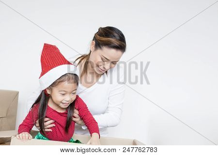 Woman Try To Hold Kid From Box. Woman Holding Kid With Happy Emotion.