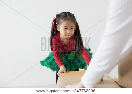 Attractive Asian Girl Try To Move A Box At Home. Kid Holding Box With Attractive Smiling. Kid With H
