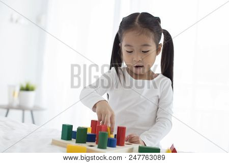 Girl Playing Toy With Attractive Smiling At Home. Happy Family Concept.