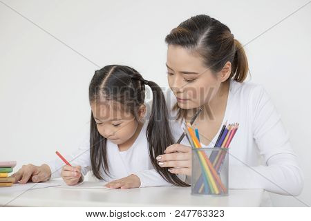 Attractive Little Girl Writing Book. Mom Teaching Her At Home. Children Lifestyle, Education Concept