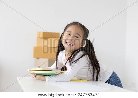 Attractive Little Girl Holding Book With Smiling. Happy Children Lifestyle, Education Concept.