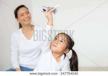 Asian Girl Playing Airplane At Home. Kid Playing Airplane With Attractive Smiling. People With Trave