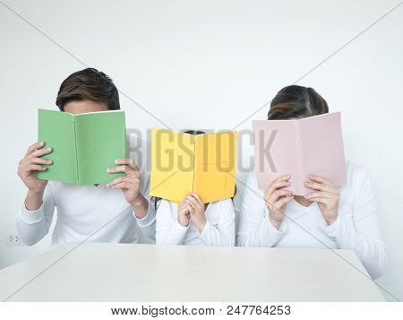 Attractive Asian Family Holding Book Together. Happy Family Concept.