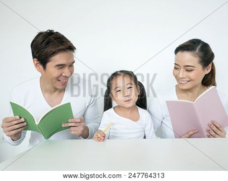 Attractive Asian Family Holding Book Together. Happy Family Concept.