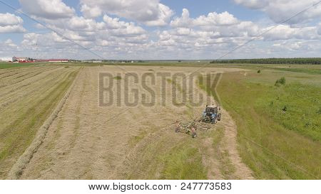 Aerial, View Agricultural Machinery With Wheeled Rake Makes Ranks Beveled Hay.tractor Which Is Linin