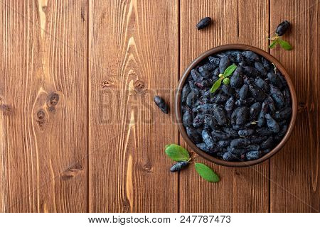 Honeysuckle Berries Or Lonicera Caerulea In Ceramic Bowl On Wooden Background