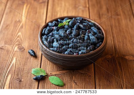 Honeysuckle Berries Or Lonicera Caerulea In Ceramic Bowl On Wooden Background