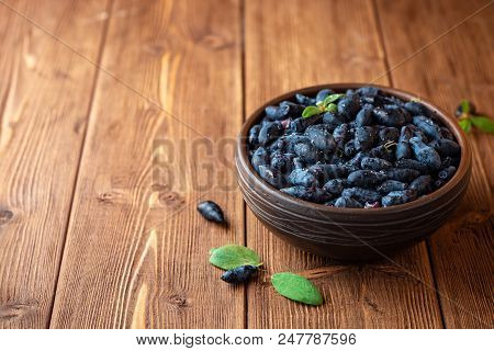 Honeysuckle Berries Or Lonicera Caerulea In Ceramic Bowl On Wooden Background