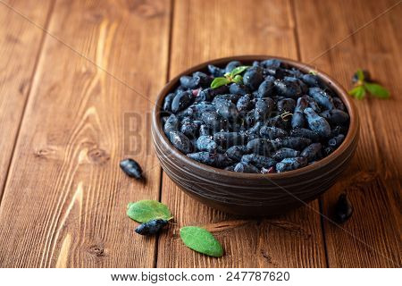 Honeysuckle Berries Or Lonicera Caerulea In Ceramic Bowl On Wooden Background
