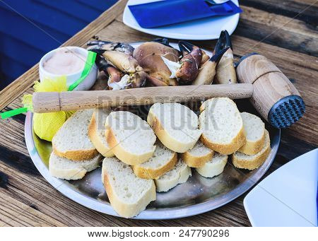 Plate With Boiled Legs And Claws Of Brown Crab With Bread And Dip On Rustic Wooden Table