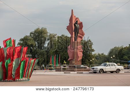 Mozyr, Belarus - September 23, 2017: Lenin statue on Lenin square with flags in  national colors and  soviet retro car in Mozyr, Southern Belarus