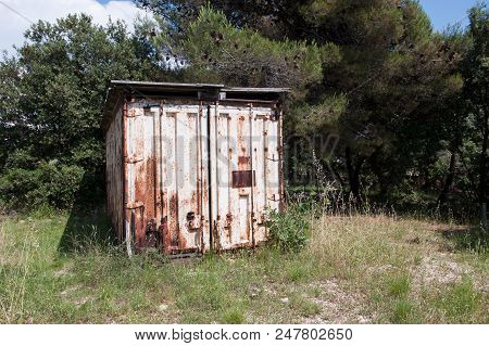 Old Rusty Metal Container In Nature. Worn Out Storage Compartment