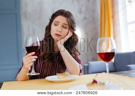 After Breakup. Young Appealing Woman Having Big Stress After Breakup While Drinking Glass Of Red Win