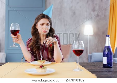 Cheerless Woman. Cheerless Woman Feeling Very Pessimistic While Sitting Alone On Her Birthday Party